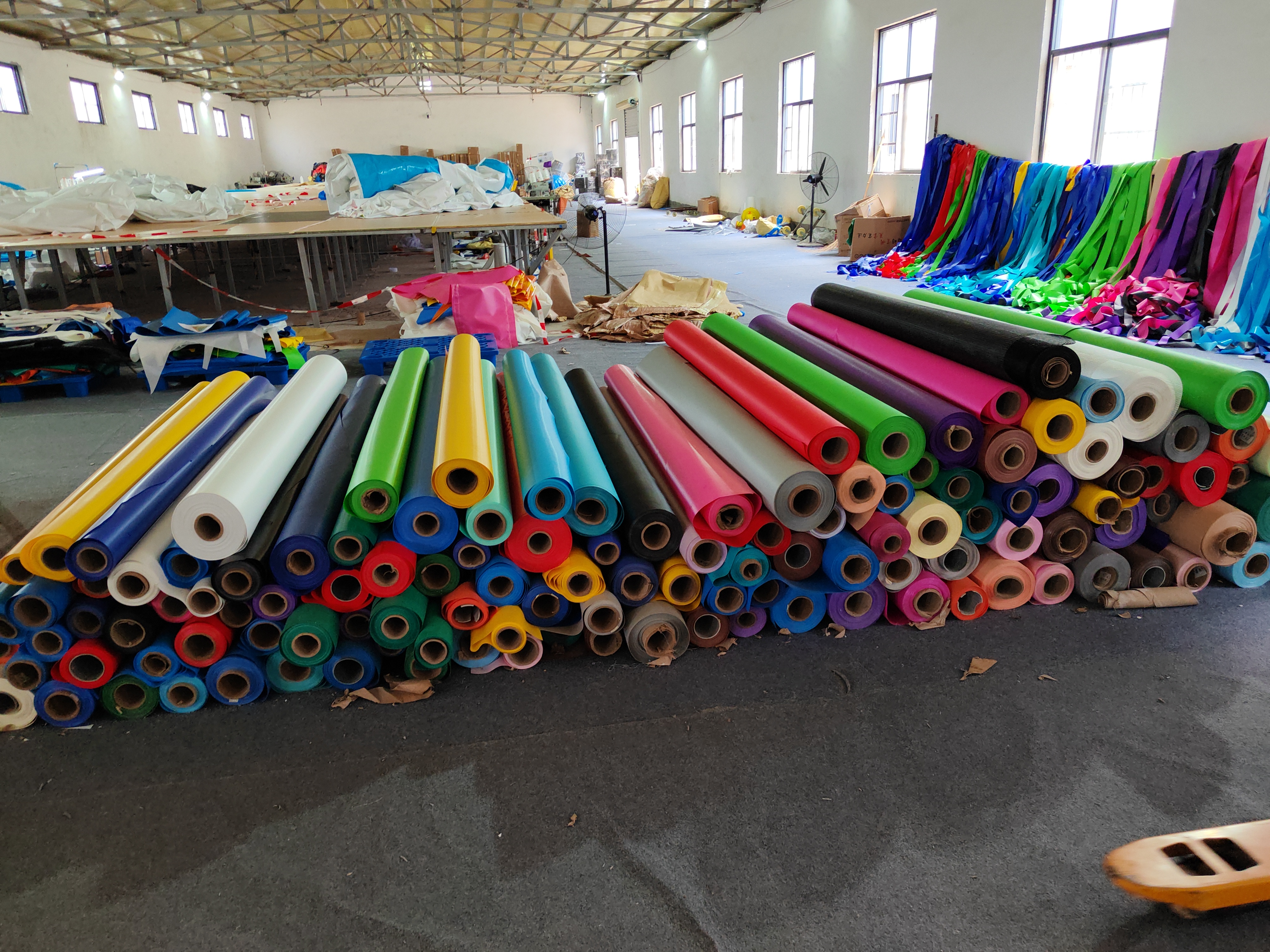 Worker selecting premium Plato PVC tarpaulin material for inflatable production