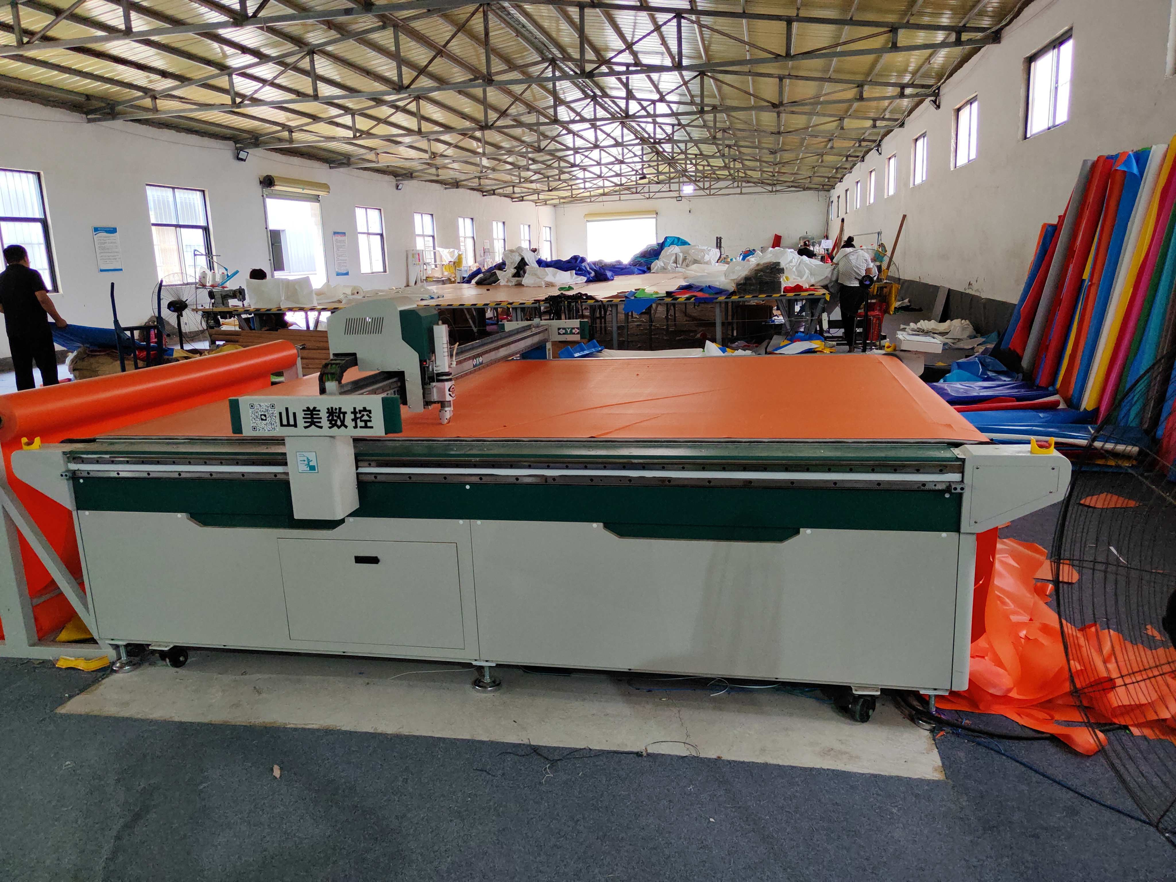 CNC machine cutting PVC tarpaulin material with precision for inflatable manufacturing